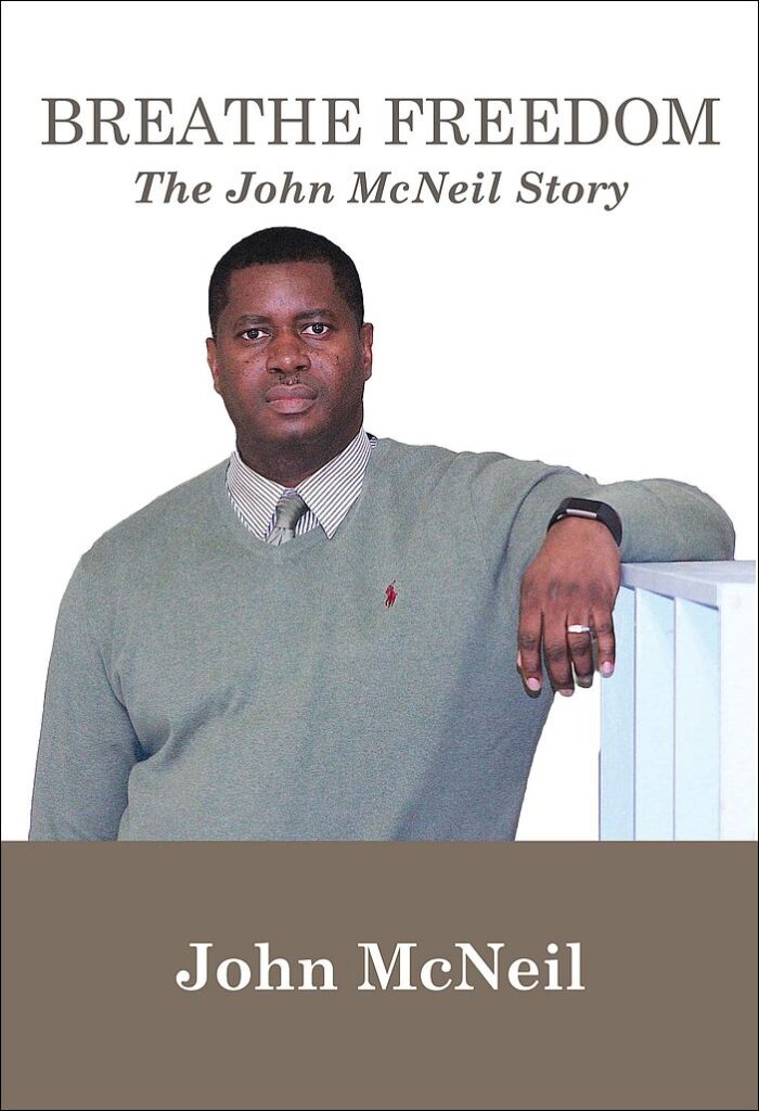 Breathe Freedom book cover: photo of John McNeil, a Black man wearing a gray sweater and tie, resting his arm on a ledge