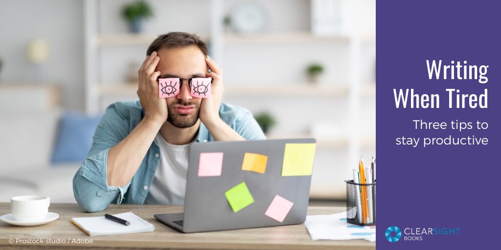 Man at his laptop, with head in hands. He has sticky notes with open eyes drawn on them stuck on top of his own eyes. Text: Writing When Tired: Three tips to stay productive.