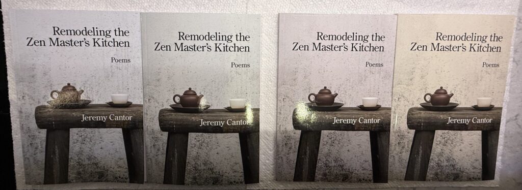 A snapshot of four print-on-demand copies of the same book. The cover as submitted was a very neutral grey. The four books are slightly blue-grey, relatively neutral grey, pinkish grey, and yellowish grey.