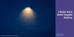 A dark brick wall appearing almost navy blue, with a single light shining down in the center. Text: A Quieter Way to Market Thoughtful Nonfiction